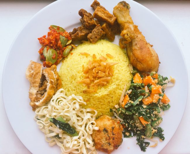 Nasi kuning dengan pelengkap ayam goreng,orek tahu tempe, sambel pete, telur dadar, mie kuning, perkedel, dan sayur urap